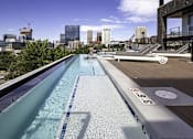 Thumbnail 2 of 7 - A rooftop pool with a city skyline in the background.