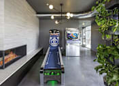 Thumbnail 5 of 7 - A bowling alley is set up in a modern room with a fireplace on the left.