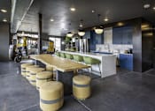 Thumbnail 4 of 7 - A modern kitchen with a long wooden table and green chairs.