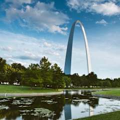 a view of the gateway arch from a park with a pond