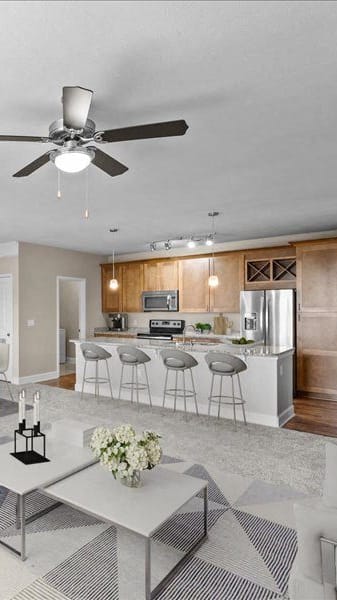 a living room and kitchen with a ceiling fan