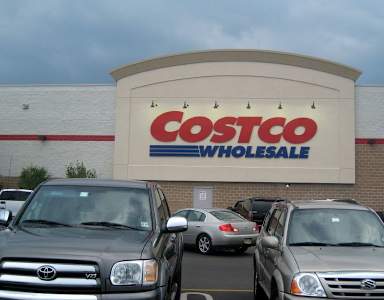 A Costco Wholesale store with cars parked in front.