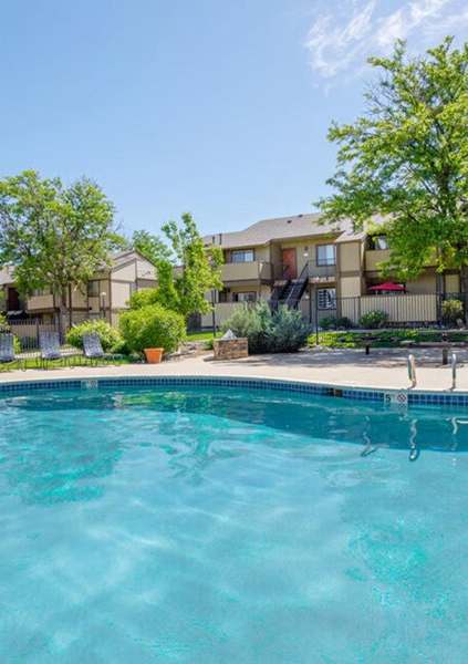 A swimming pool in front of apartment buildings.