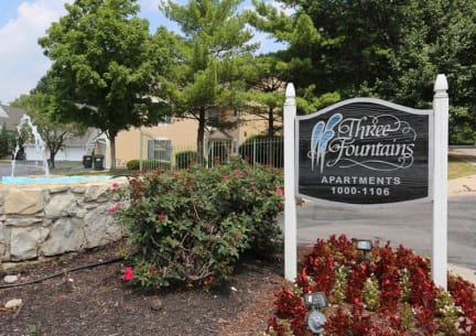 a sign in front of a building with trees in the background