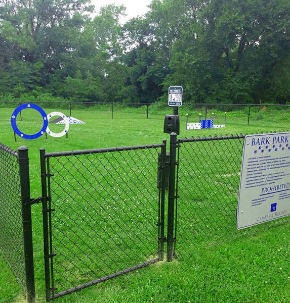 a dog park with a sign on a fence