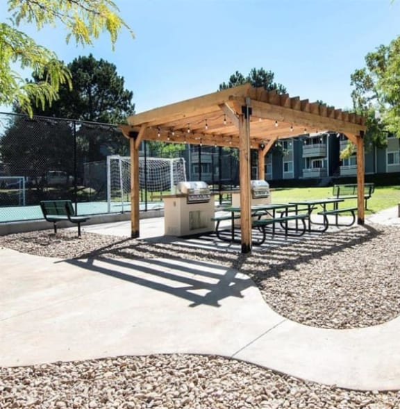 a patio with a grill and a pergola