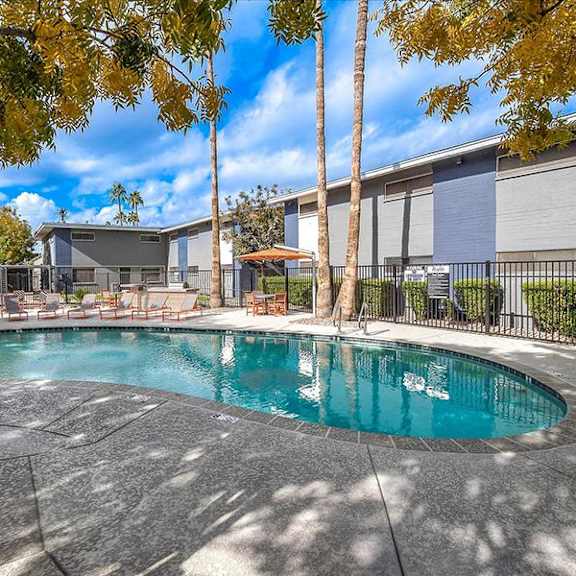 a swimming pool with palm trees next to a building