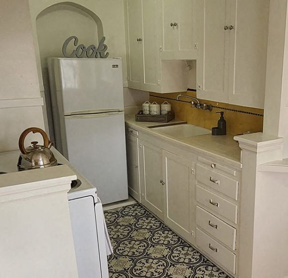 a kitchen with white cabinets and a refrigerator