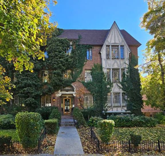 the front of a house with a garden and a sidewalk