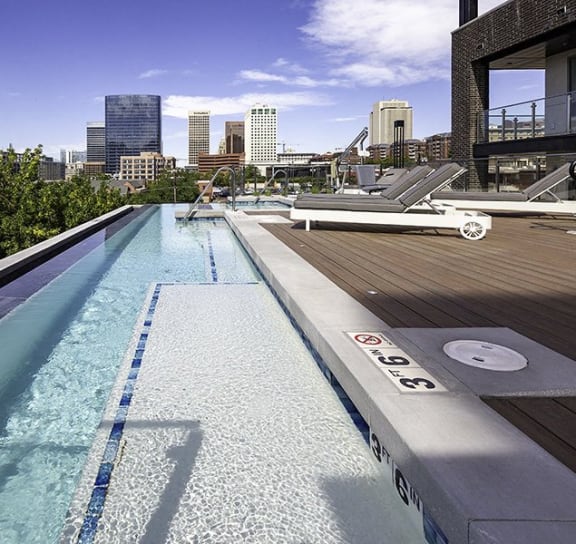 a pool on a rooftop with a city in the background