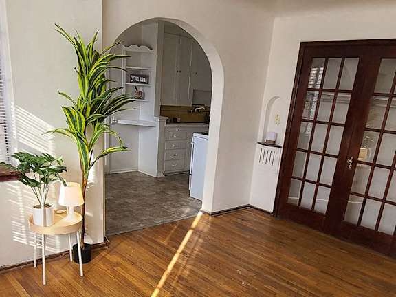a living room with a wooden floor and a door