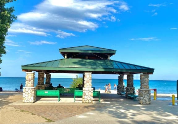 a pavilion on the beach with the ocean in the background