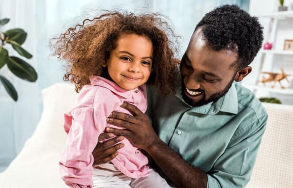 happy man and girl sitting in room