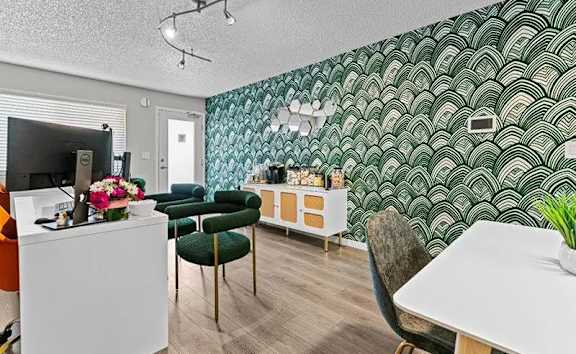 A room with a white desk and a green chair.