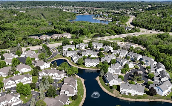 A bird's eye view of a residential area with houses surrounding a river.