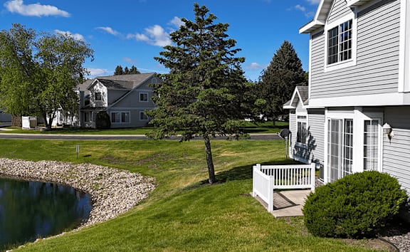 A house with a white fence and a tree in front of it.