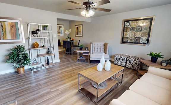 A living room with a white sofa and a wooden coffee table.