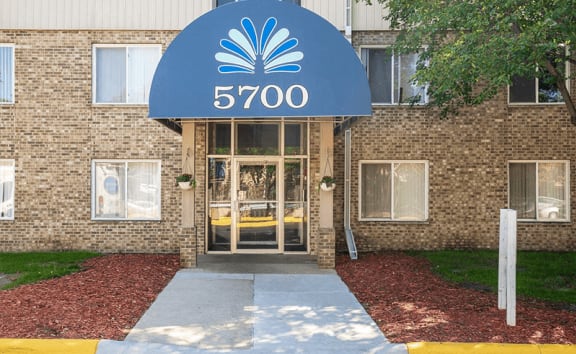 a brick building at fountains in the park with a blue sign that says 5700