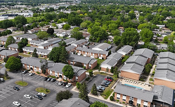 A bird's eye view of a residential area with houses and parked cars.