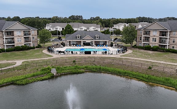 A fountain in the middle of a lake in a residential area.