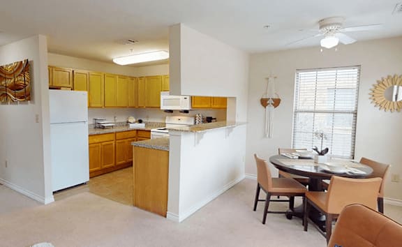 A kitchen with a white refrigerator and wooden cabinets.