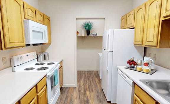 A kitchen with wooden cabinets and white appliances.