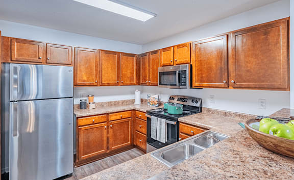A kitchen with wooden cabinets and granite countertops.