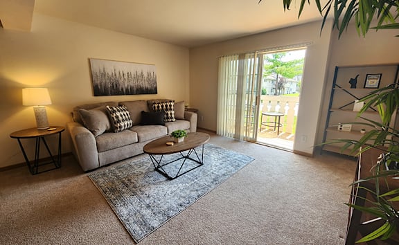 A living room with a couch, a coffee table, and a painting on the wall.