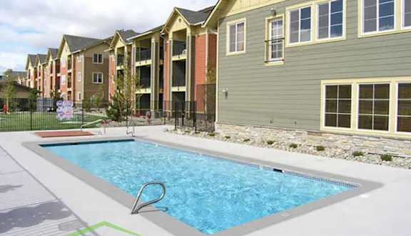 A swimming pool in front of apartment buildings.
