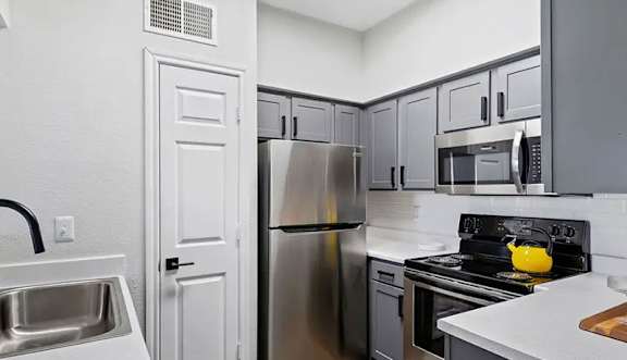 A kitchen with a stainless steel refrigerator and oven.