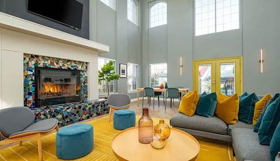A living room with a fireplace and a TV mounted on the wall.