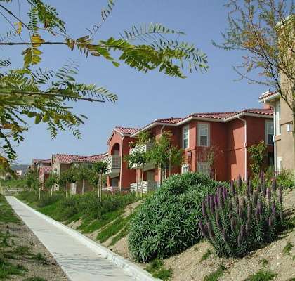 a row of houses on the side of a sidewalk
