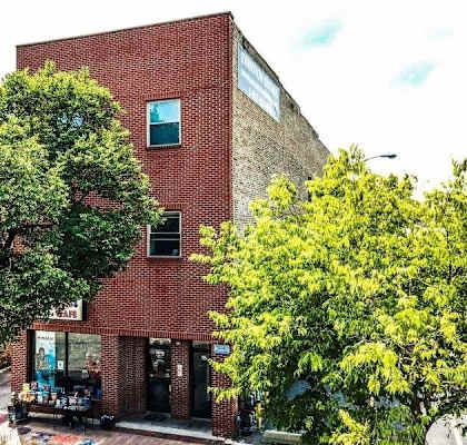 A red brick building with a tree in front of it.