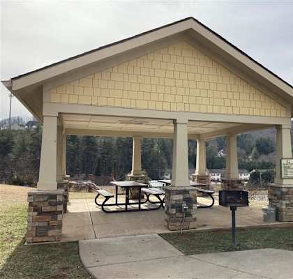 A covered picnic area with a table and chairs.