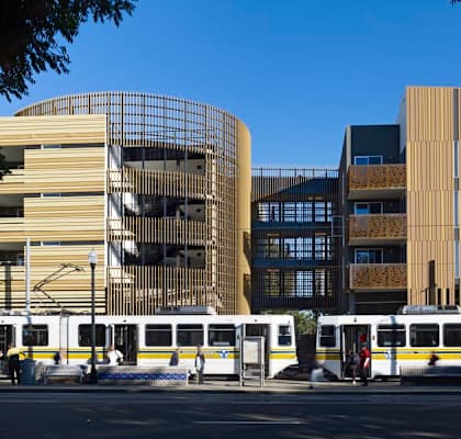 A train station with a curved building and a straight building next to it.