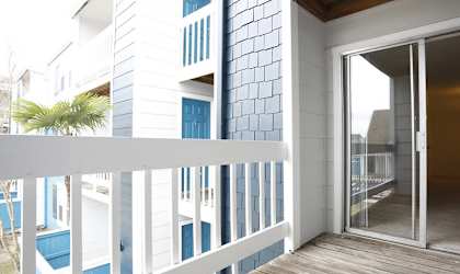 a balcony with a door and a palm tree