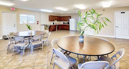 A dining room with a round table and chairs.