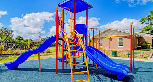 A playground with a blue slide and a yellow structure.