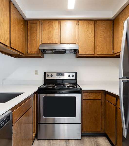 A modern kitchen with a stainless steel refrigerator and oven.