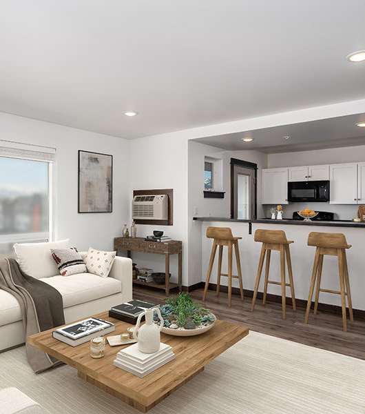 A modern living room with a white sofa, a wooden coffee table, and a kitchen area in the background.