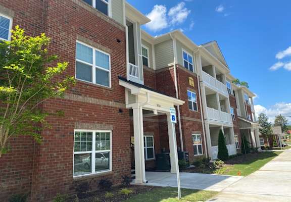 A row of townhouses with a blue sign in front.