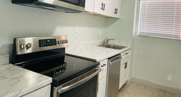 a kitchen with a stove microwave and sink