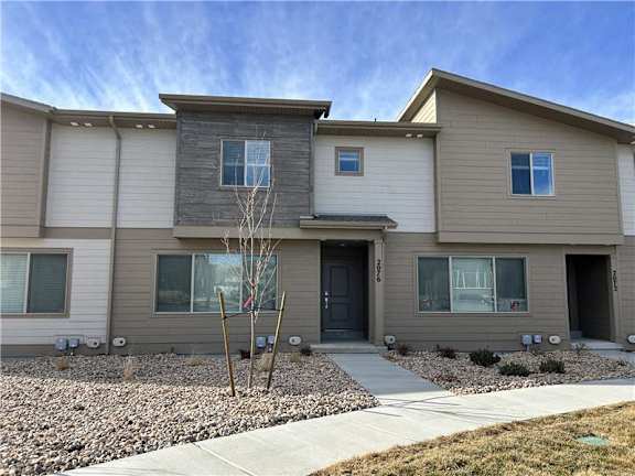 A modern two-story house with a grey and beige exterior.