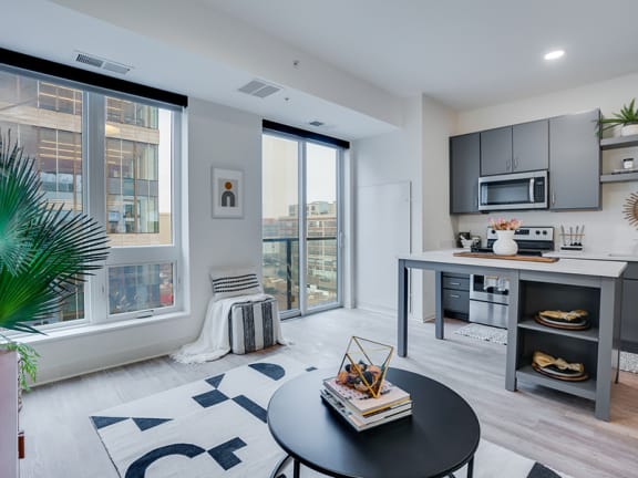 an open living room with a kitchen and a large window