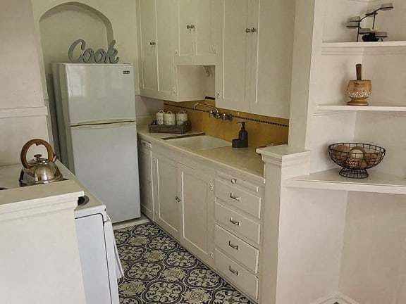 a kitchen with white cabinets and a white refrigerator