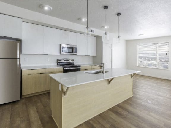 a kitchen with an island and a stainless steel refrigerator