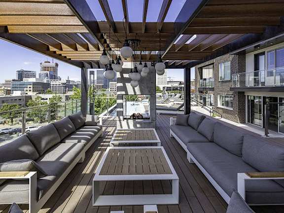A wooden deck with a couch and a table.