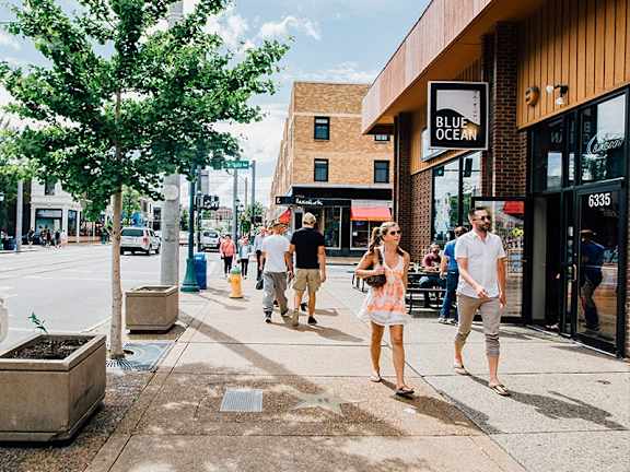 a couple walking down the sidewalk on a busy city street