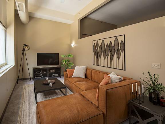 A living room with a brown leather couch and a black coffee table.