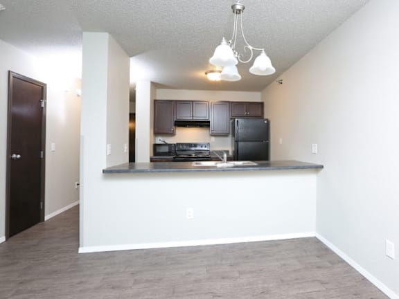 A kitchen with a bar area and a refrigerator.